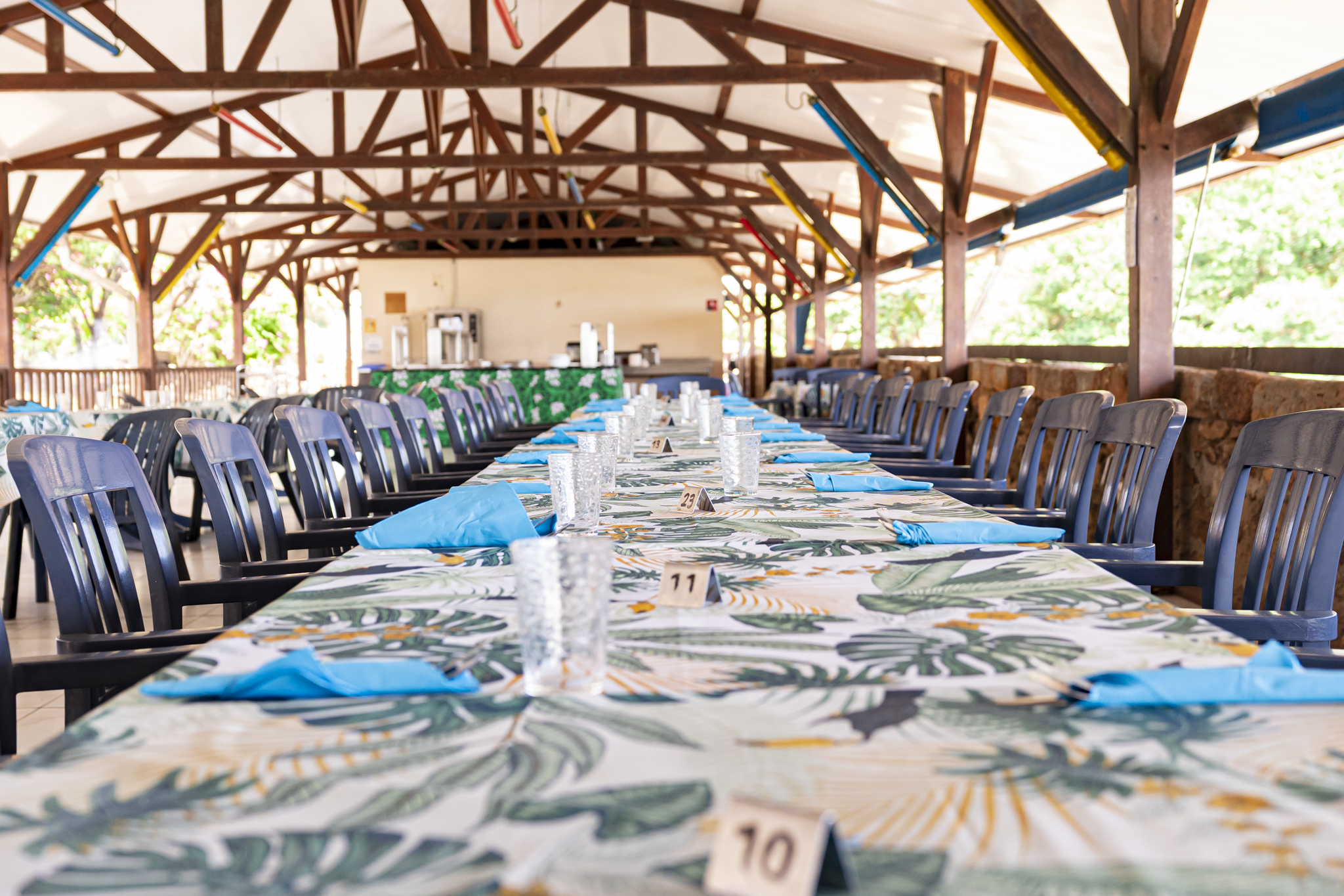 Le bar de l’Hostellerie : luminaires en rotin, fauteuils tressés et plantes tropicales